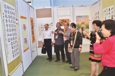 第六屆海峽兩岸老年書畫交流會(huì)漳州舉行 展覽為(圖1) 書畫攝影愛好者賞評(píng)海峽兩岸老年書畫交流會(huì)參展作品 (記者 張偉斌 攝)